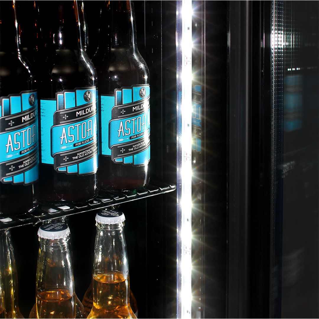 Beer bottles inside bar fridge on stainless steel shelves